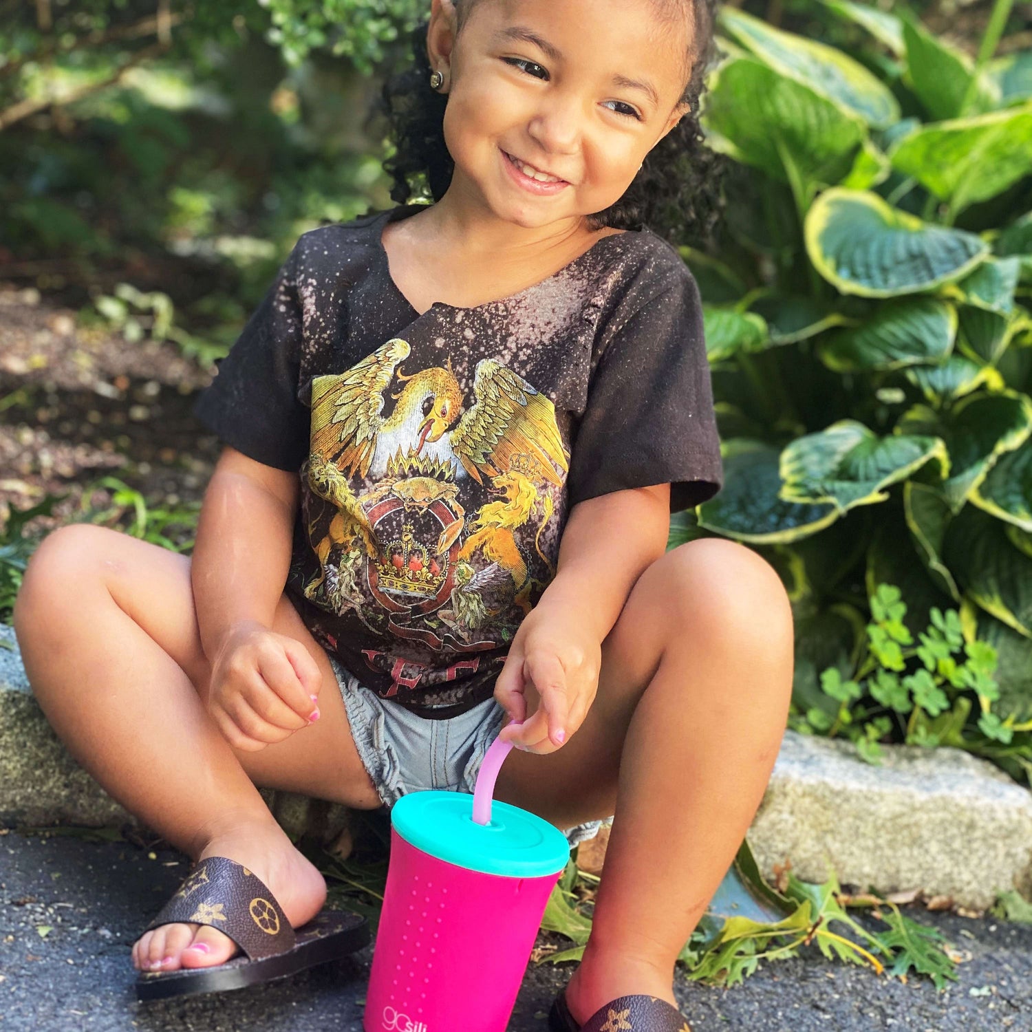 Child drinking from a GoSili cup with a silicone straw lid, showcasing a fun, colorful design.
