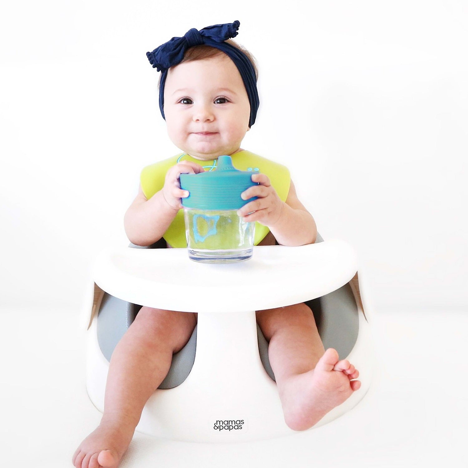 Parent stretching a GoSili sippy cup lid over a glass for spill-free hydration.
